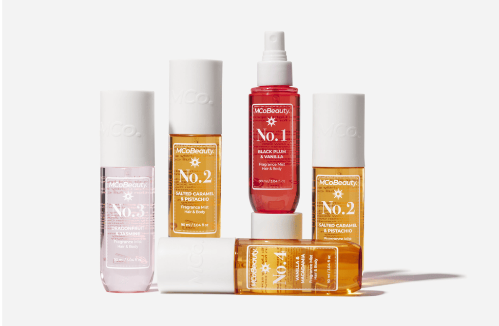 Five fragrance mist bottles from McBeauty, including scents like Black Plum & Vanilla, Salted Caramel & Pistachio, and Dragonfruit & Jasmine.